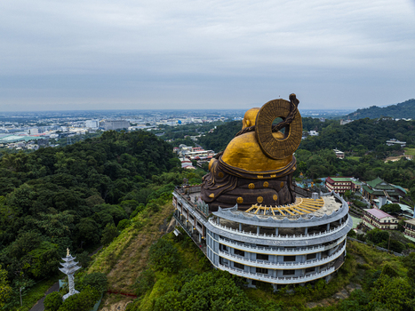 Aerial view of the large golden Buddha statue overlooking the lush green hills and surrounding temple complex in Jiuru Township Pingtung County Taiwan. Aerial view of the large golden Buddha statue overlooking the lush green hills and surrounding temple complex in Jiuru Township Pingtung County Taiwan.