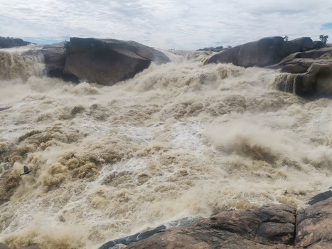 View of Augrabies Falls with powerful torrents of water cascading over rugged cliffs into the Orange River gorge creating mist and spray in Augrabies Northern Cape South Africa.