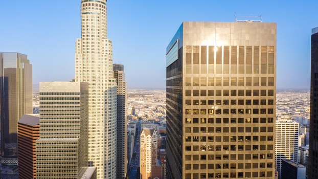 Aerial view of the Los Angeles skyline featuring the US Bank Tower and modern skyscrapers under a clear blue sky in Los Angeles California United States.
