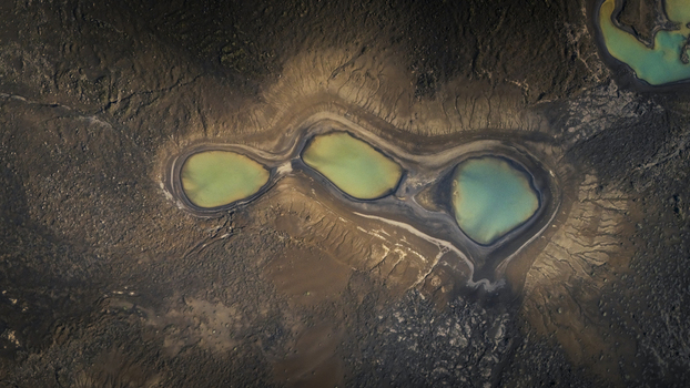 Aerial view of turquoise glacial lakes set within a dark textured volcanic landscape in the highlands of Vik Myrdalshreppur Iceland. Aerial view of turquoise glacial lakes set within a dark textured volcanic landscape in the highlands of Vik Myrdalshreppur Iceland.