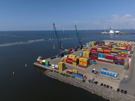 Aerial view of TMA Terminals Lelystad with colorful shipping containers industrial cranes and calm water in Lelystad Flevoland Netherlands. Aerial view of TMA Terminals Lelystad with colorful shipping containers industrial cranes and calm water in Lelystad Flevoland Netherlands.