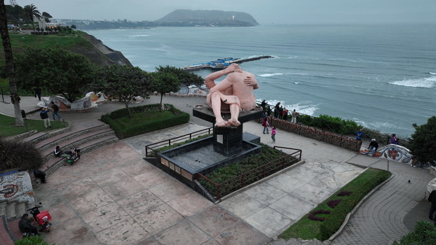 Aerial view of Love Park featuring the El Beso sculpture overlooking the Pacific Ocean coastline with people walking along the paths in Miraflores Provincia de Lima Peru.