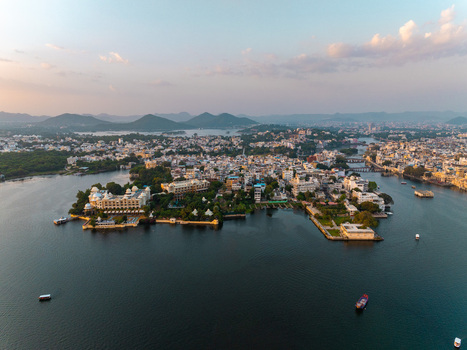 Aerial view of the historic city of Udaipur with its grand palaces and hotels situated on the banks of Lake Pichola surrounded by hills in Udaipur Rajasthan India.