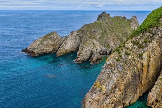 Aerial view of dramatic rocky cliffs and turquoise waters at Silence Beach Viewpoint Cudillero Asturias Spain.