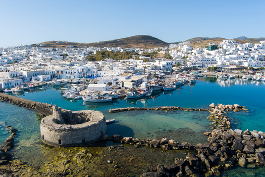 Naoussa Greece 21 September 2026 Aerial view of the Venetian castle ruins in the harbor with white buildings and fishing boats in the background. Naoussa Greece 21 September 2026 Aerial view of the Venetian castle ruins in the harbor with white buildings and fishing boats in the background.