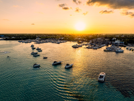 Aerial view of Club Nautico de Santo Domingo Inc. with numerous yachts and boats moored in the marina during a golden sunset in Andres Santo Domingo Dominican Republic. Aerial view of Club Nautico de Santo Domingo Inc. with numerous yachts and boats moored in the marina during a golden sunset in Andres Santo Domingo Dominican Republic.