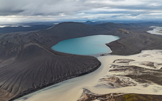 Aerial view of the turquoise crater lake in Landmannalaugar surrounded by dark volcanic ash fields and braided glacial rivers in Rangarthing ytra Iceland. Aerial view of the turquoise crater lake in Landmannalaugar surrounded by dark volcanic ash fields and braided glacial rivers in Rangarthing ytra Iceland.
