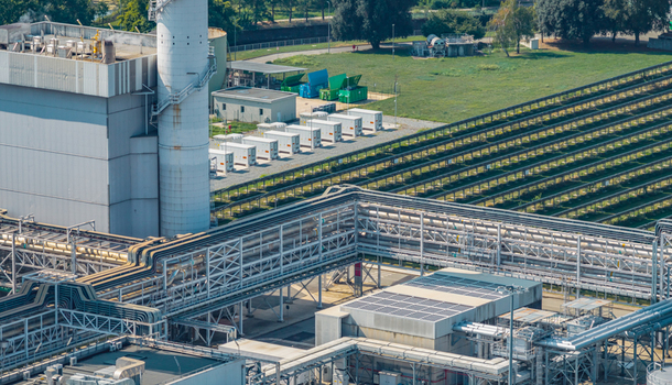 Aerial view of industrial pipelines power generation equipment and battery storage systems at a modern energy facility in Chivasso Piedmont Italy.