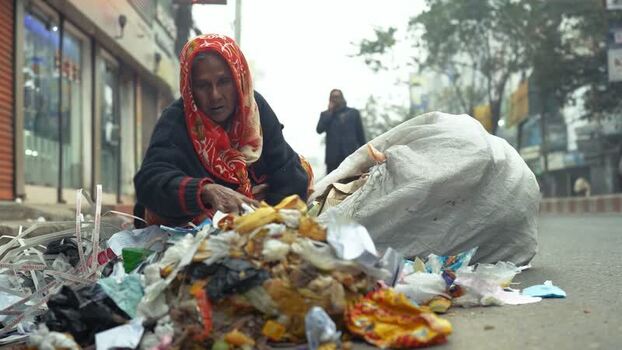 View of an elderly woman sorting garbage in Bogura Bangladesh. View of an elderly woman sorting garbage in Bogura Bangladesh.