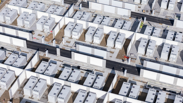 Aerial view of a large industrial site featuring rows of white modular storage containers arranged within partitioned sections in Poland.