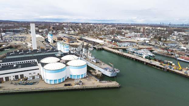 Aerial view of industrial buildings tanks ships and docks meet the water s edge under a muted sky Quincy Massachusetts United States.