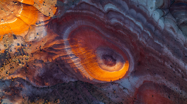 Aerial view of colorful eroded badlands in the Utah desert showcasing intricate geological layers and vibrant orange and red rock formations Hanksville Utah United States.