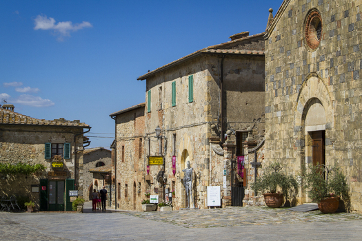View of ancient stone buildings basking under a clear blue sky their weathered facades hinting at centuries of stories Monteriggioni Tuscany Italy. View of ancient stone buildings basking under a clear blue sky their weathered facades hinting at centuries of stories Monteriggioni Tuscany Italy.