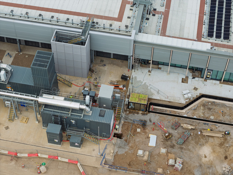 Aerial view of a data center construction site featuring industrial cooling units pipes and construction materials in the United Kingdom.