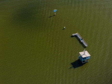 Aerial view of the Berlin Grunau Regatta Course featuring a small structure and a pier extending into the calm water in Berlin Berlin Germany. Aerial view of the Berlin Grunau Regatta Course featuring a small structure and a pier extending into the calm water in Berlin Berlin Germany.