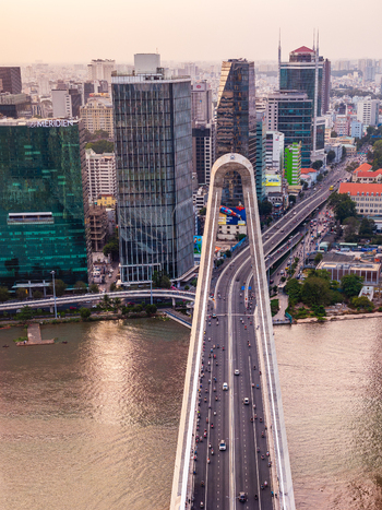 Aerial view of Thu Thiem Bridge with traffic flowing over the Saigon River surrounded by modern skyscrapers and urban development in Ho Chi Minh City Vietnam. Aerial view of Thu Thiem Bridge with traffic flowing over the Saigon River surrounded by modern skyscrapers and urban development in Ho Chi Minh City Vietnam.