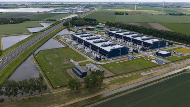 Aerial view of the large modern data center buildings at Agriport business park with surrounding canals green fields and a highway in Middenmeer Noord Holland Netherlands. Aerial view of the large modern data center buildings at Agriport business park with surrounding canals green fields and a highway in Middenmeer Noord Holland Netherlands.