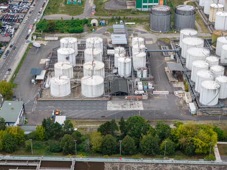 Aerial view of the TanQuid Tanklager Berlin industrial storage facility with white cylindrical tanks complex piping systems and paved grounds in Berlin Berlin Germany.
