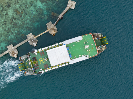 Aerial view of a ferry boat docked near a pier with turquoise waters and lush greenery Karimunjawa Jawa Tengah Indonesia. Aerial view of a ferry boat docked near a pier with turquoise waters and lush greenery Karimunjawa Jawa Tengah Indonesia.
