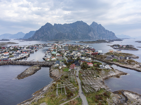 Aerial view of the village nestled among the islands with rugged mountains rising in the background Henningsvær Nordland Norway. Aerial view of the village nestled among the islands with rugged mountains rising in the background Henningsvær Nordland Norway.