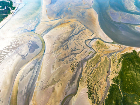 Aerial view of Baie de Somme showing intricate tidal channels vast sandbanks and coastal greenery in Saint Valery sur Somme Hauts de France France. Aerial view of Baie de Somme showing intricate tidal channels vast sandbanks and coastal greenery in Saint Valery sur Somme Hauts de France France.