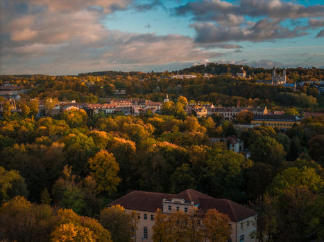 Aerial view of a tapestry of autumnal hues drapes the landscape with the old town s terracotta roofs nestled amidst the vibrant foliage Vilnius Lithuania. Aerial view of a tapestry of autumnal hues drapes the landscape with the old town s terracotta roofs nestled amidst the vibrant foliage Vilnius Lithuania.
