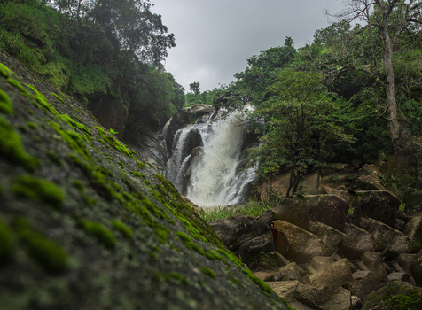 View of a cascading waterfall surrounded by mossy rocks and lush green vegetation in Jos Plateau Nigeria. View of a cascading waterfall surrounded by mossy rocks and lush green vegetation in Jos Plateau Nigeria.
