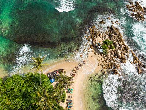 Aerial view of Secret Beach Mirissa with turquoise waves crashing against rocky shores and palm trees lining the sandy coast Mirissa Southern Province Sri Lanka. Aerial view of Secret Beach Mirissa with turquoise waves crashing against rocky shores and palm trees lining the sandy coast Mirissa Southern Province Sri Lanka.