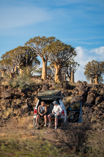 Aussenkehr Namibia 06 March 2026 View of two figures silhouetted against the bright sky the rugged terrain dotted with quiver trees. Aussenkehr Namibia 06 March 2026 View of two figures silhouetted against the bright sky the rugged terrain dotted with quiver trees.