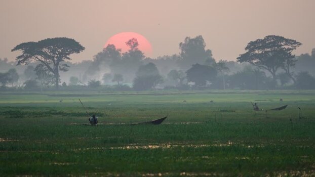 View of fishermen in boats at sunset in Bogura Bangladesh.