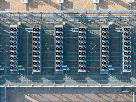 Aerial view of Vantage Data Centers BER1 rooftop with rows of industrial cooling fans and HVAC units Ludwigsfelde Brandenburg Germany. Aerial view of Vantage Data Centers BER1 rooftop with rows of industrial cooling fans and HVAC units Ludwigsfelde Brandenburg Germany.