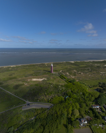 Aerial view of Westhoofd Lighthouse standing amidst coastal dunes and greenery near the North Sea in Ouddorp Zuid Holland Netherlands. Aerial view of Westhoofd Lighthouse standing amidst coastal dunes and greenery near the North Sea in Ouddorp Zuid Holland Netherlands.