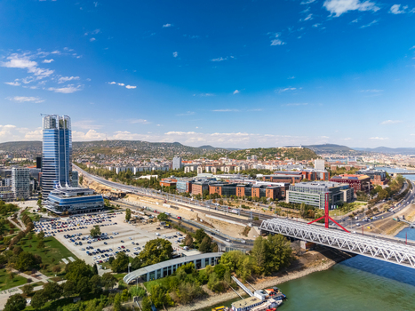 Aerial view of Mol Tower and the Budapest business district by the Danube near Rakoczi Bridge with modern office buildings roads and riverside parks in summer. Aerial view of Mol Tower and the Budapest business district by the Danube near Rakoczi Bridge with modern office buildings roads and riverside parks in summer.