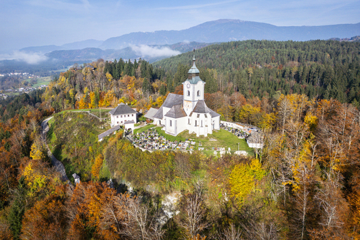 Aerial view of the glistening white church perched atop a hill surrounded by a vibrant tapestry of autumn colors Sternberg Kärnten Austria. Aerial view of the glistening white church perched atop a hill surrounded by a vibrant tapestry of autumn colors Sternberg Kärnten Austria.