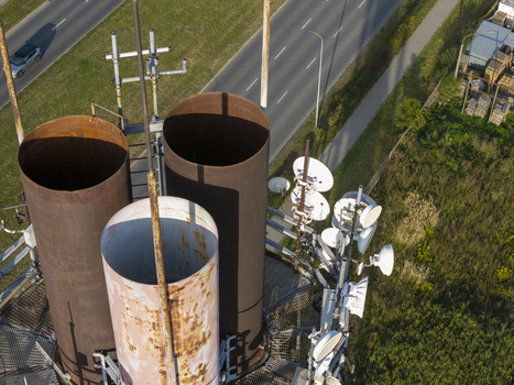 Aerial view of a telecommunications tower featuring large rusted metal pipes and multiple satellite dishes situated near a road in Krakow Lesser Poland Voivode Poland.