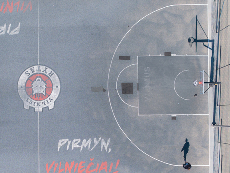 Vilnius Lithuania 20 April 2026 Aerial view of a basketball court with the Vilnius Rytas logo painted on the surface featuring a hoop and a person walking nearby. Vilnius Lithuania 20 April 2026 Aerial view of a basketball court with the Vilnius Rytas logo painted on the surface featuring a hoop and a person walking nearby.