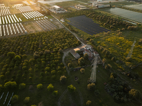 Aerial view of solar panel arrays and lush citrus orchards near farm buildings during golden hour Augusta Sicily Italy. Aerial view of solar panel arrays and lush citrus orchards near farm buildings during golden hour Augusta Sicily Italy.