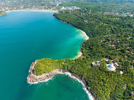 Aerial view of Japanese Peace Pagoda Rumassala surrounded by lush tropical forest and turquoise ocean waters in Unawatuna Southern Province Sri Lanka. Aerial view of Japanese Peace Pagoda Rumassala surrounded by lush tropical forest and turquoise ocean waters in Unawatuna Southern Province Sri Lanka.