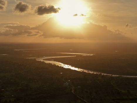 Aerial view of River Sabaki winding through the landscape at sunset with golden light reflecting on the water in Malindi Kilifi County Kenya.