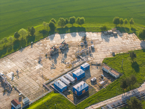 Aerial view of the UGS Damborice facility featuring oil pump jacks and blue industrial buildings surrounded by lush green fields and trees Damborice South Moravian Region Czechia. Aerial view of the UGS Damborice facility featuring oil pump jacks and blue industrial buildings surrounded by lush green fields and trees Damborice South Moravian Region Czechia.
