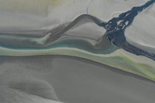 Aerial view of braided glacial river channels with sediment rich water flowing through the Alaska Wilderness Girdwood Alaska United States. Aerial view of braided glacial river channels with sediment rich water flowing through the Alaska Wilderness Girdwood Alaska United States.