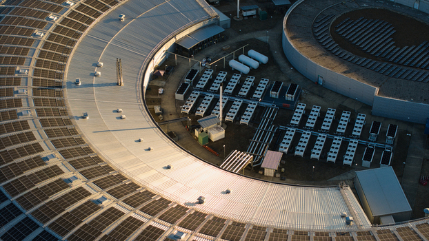 Aerial view of Diamond Light Source a circular synchrotron facility surrounded by greenery under golden hour light in Didcot United Kingdom.