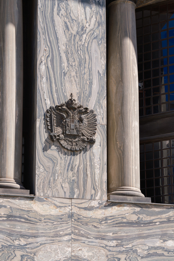 View of the imperial double headed eagle coat of arms mounted on a grey veined marble wall between classical columns Vienna Vienna Austria. View of the imperial double headed eagle coat of arms mounted on a grey veined marble wall between classical columns Vienna Vienna Austria.