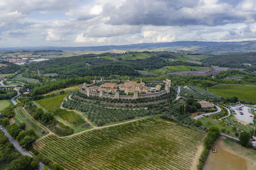 Aerial view of the fortified medieval town of Monteriggioni enclosed by stone walls surrounded by vineyards and olive groves in the Tuscan countryside Monteriggioni Tuscany Italy.