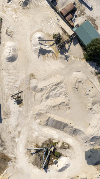 Aerial view of Extraccion de aridos Lima S.L. quarry featuring piles of sand gravel and industrial processing machinery in Vilarino das Poldras Ourense Spain. Aerial view of Extraccion de aridos Lima S.L. quarry featuring piles of sand gravel and industrial processing machinery in Vilarino das Poldras Ourense Spain.