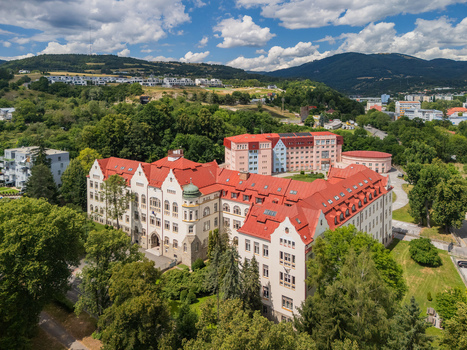 Aerial view of the Faculty of Economics at Matej Bel University featuring red roofed historic architecture surrounded by trees and hills in Banska Bystrica Banskobystricky kraj Slovakia. Aerial view of the Faculty of Economics at Matej Bel University featuring red roofed historic architecture surrounded by trees and hills in Banska Bystrica Banskobystricky kraj Slovakia.
