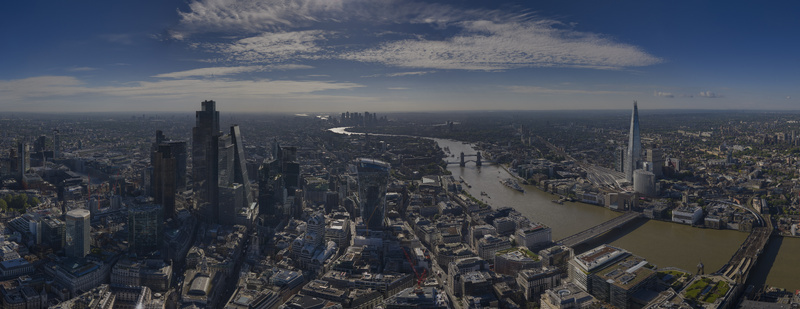 Aerial view of The Fenchurch Building and the London skyline with the River Thames Tower Bridge and The Shard under a blue sky London England United Kingdom. Aerial view of The Fenchurch Building and the London skyline with the River Thames Tower Bridge and The Shard under a blue sky London England United Kingdom.
