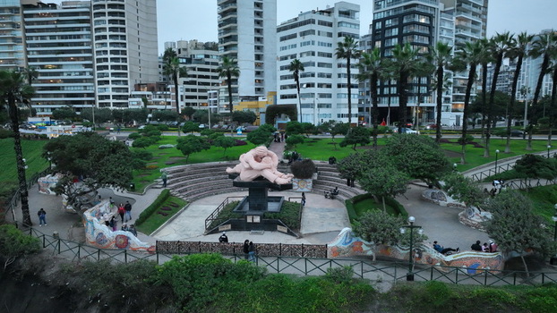 Aerial view of Love Park with its iconic sculpture surrounded by lush gardens pathways and modern apartment buildings in Miraflores Provincia de Lima Peru. Aerial view of Love Park with its iconic sculpture surrounded by lush gardens pathways and modern apartment buildings in Miraflores Provincia de Lima Peru.