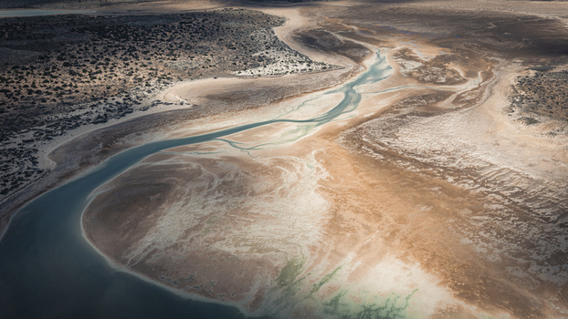 Aerial view of abstract patterns of blue water and brown sands along the coastline in Useless Loop Western Australia Australia. Aerial view of abstract patterns of blue water and brown sands along the coastline in Useless Loop Western Australia Australia.