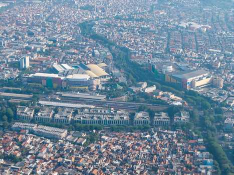 Surabaya Indonesia 29 August 2026 Aerial view of dense urban landscape featuring large commercial buildings a railway line and residential rooftops under a clear sky. Surabaya Indonesia 29 August 2026 Aerial view of dense urban landscape featuring large commercial buildings a railway line and residential rooftops under a clear sky.